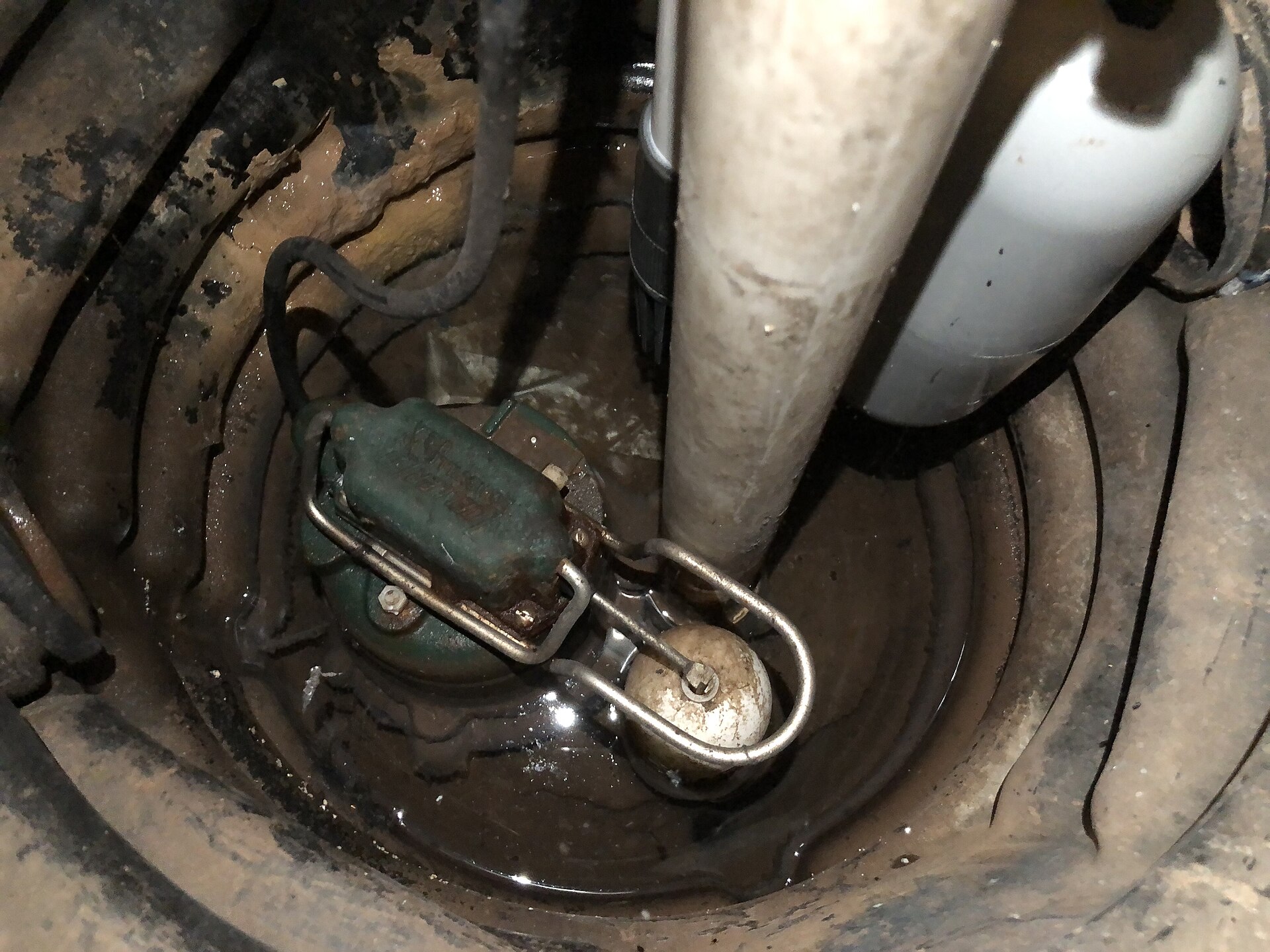 A submersible sump pump with float switch in a basement sump pit